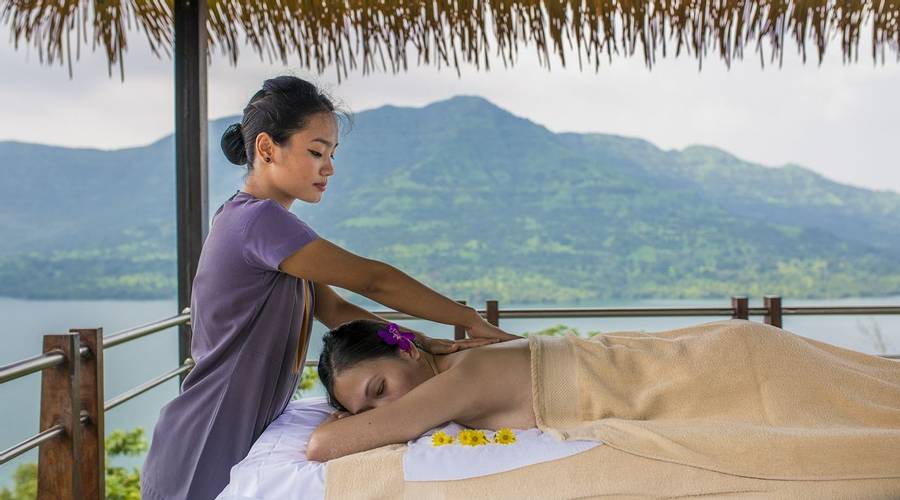 Woman receiving a massage outdoors from a female masseuse