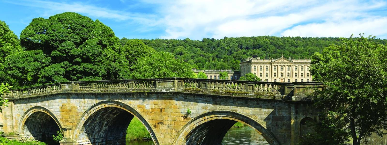 Stone road bridge over the River Derwent at Chatsworth house estate, Derbyshire.