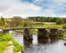 Ancient clapper bridge over the East Dart river at Postbridge in Dartmoor National Park in Devon UK Europe