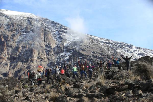 Hikers at the summit of Kilimanjaro, Uhuru Peak, holding up an EverTrek banner