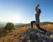 Healthy woman enjoying the beautiful nature, rising her arms while stretching toward the setting sun. Lifestyle and fitness …