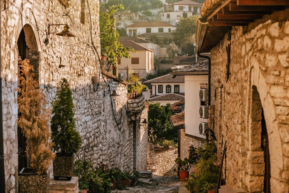Cobbled street in Mangalem district of Berat Old Town, popular travel destination in Albania. Summer cityscape with unique O…