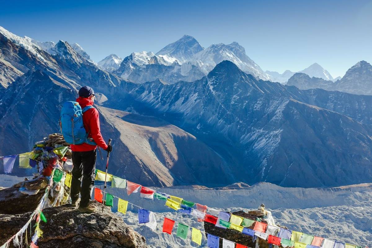 Active hiker hiking, enjoying the view, looking at Himalaya mountains landscape. mountaineering sport lifestyle concept