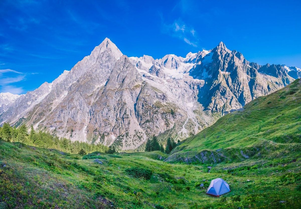Camping on the slopes of Val Ferret observing the Grandes Jorasses duringthe morning. Marmot burrows are everywherem one of …