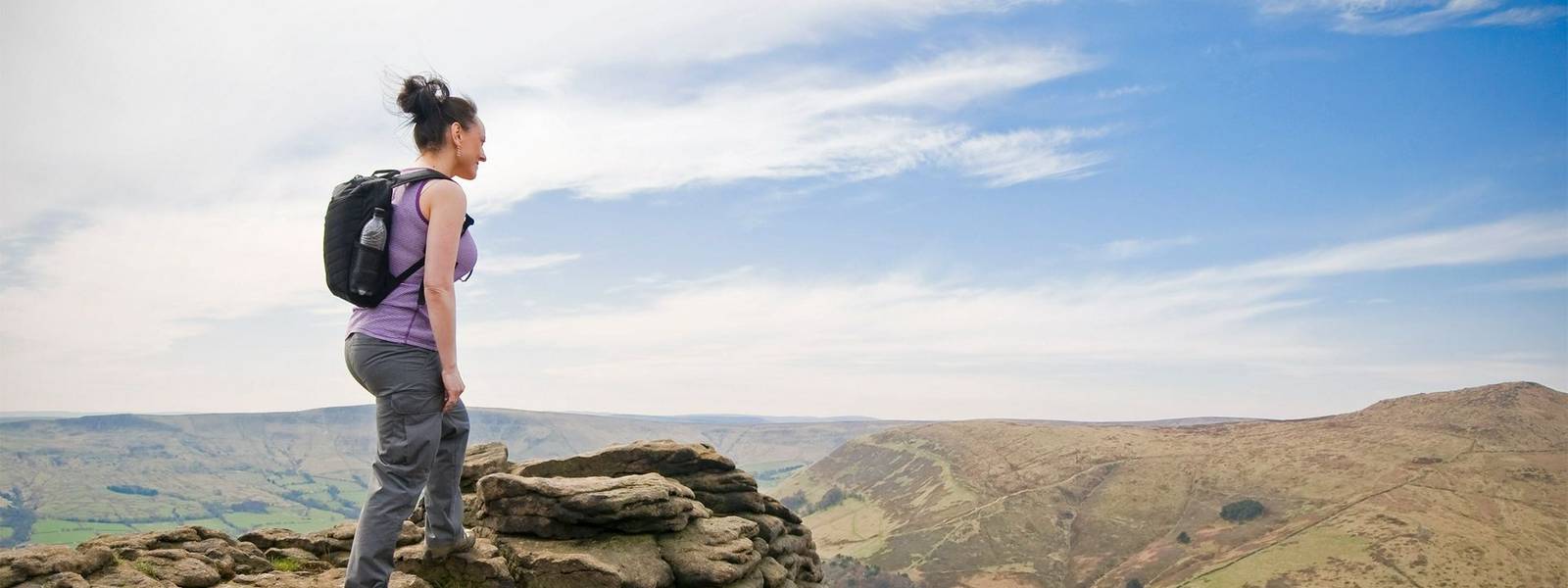 woman hiking on mountains at Kinder Plateau, Peak District, England