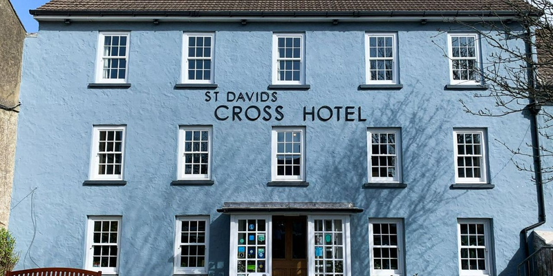 Large, square 3-storey building with blue painted brickwork