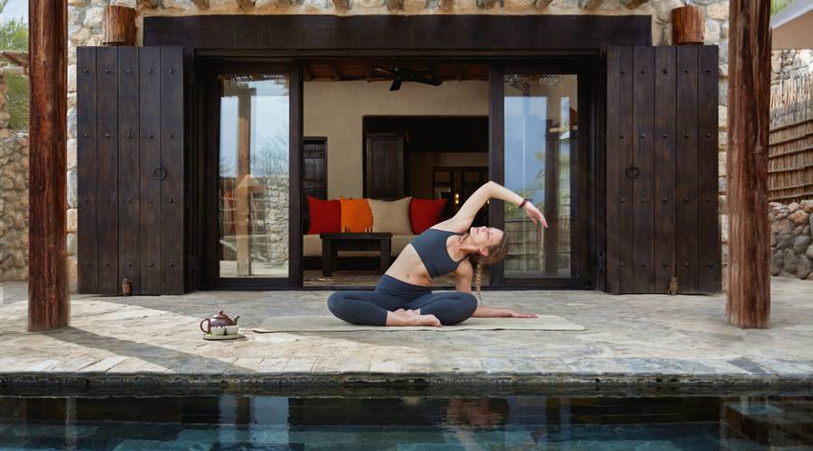 Woman practicing yoga at Six Senses Zighy Bay in Oman