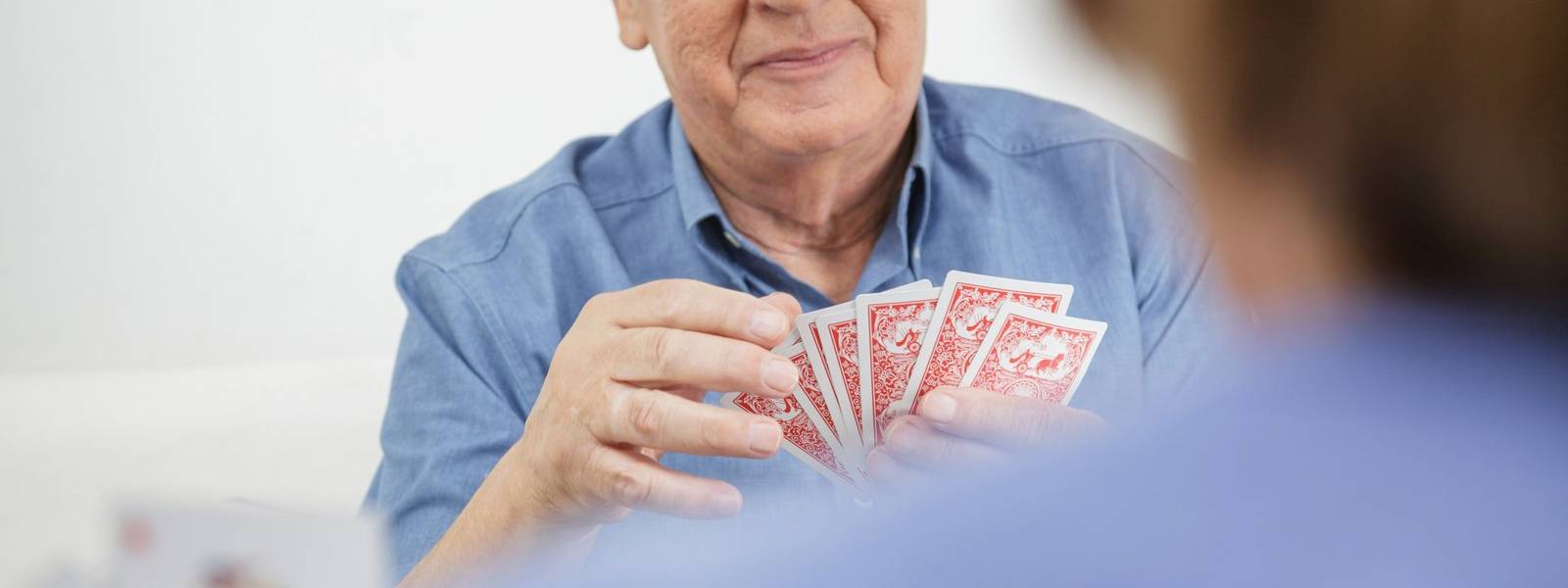 senior woman on couch playing cards with husband