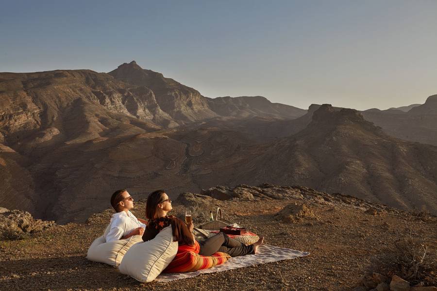 Couple looking out at the desert terrain at Six Senses Zighy Bay in Oman