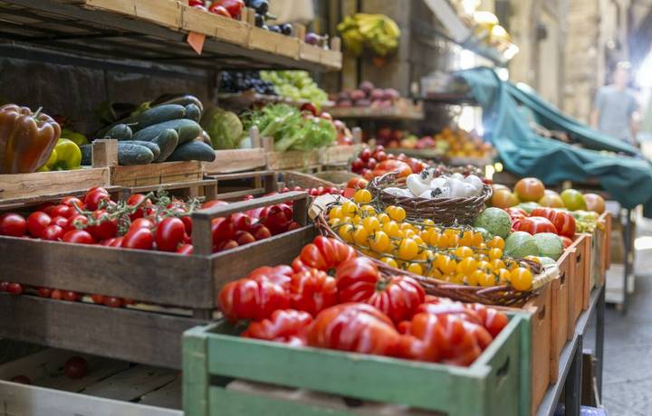 Fresh and healthy vegetables and colorful fruit in front of a shop in a picturesque street in Italy Fresh and healthy vegetables and colorful fruit in front of a shop in a picturesque street in Italy