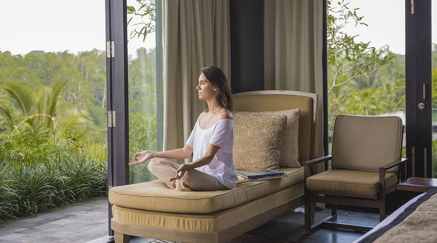 Woman meditating in her hotel room. meditation is great for both your physical and mental health