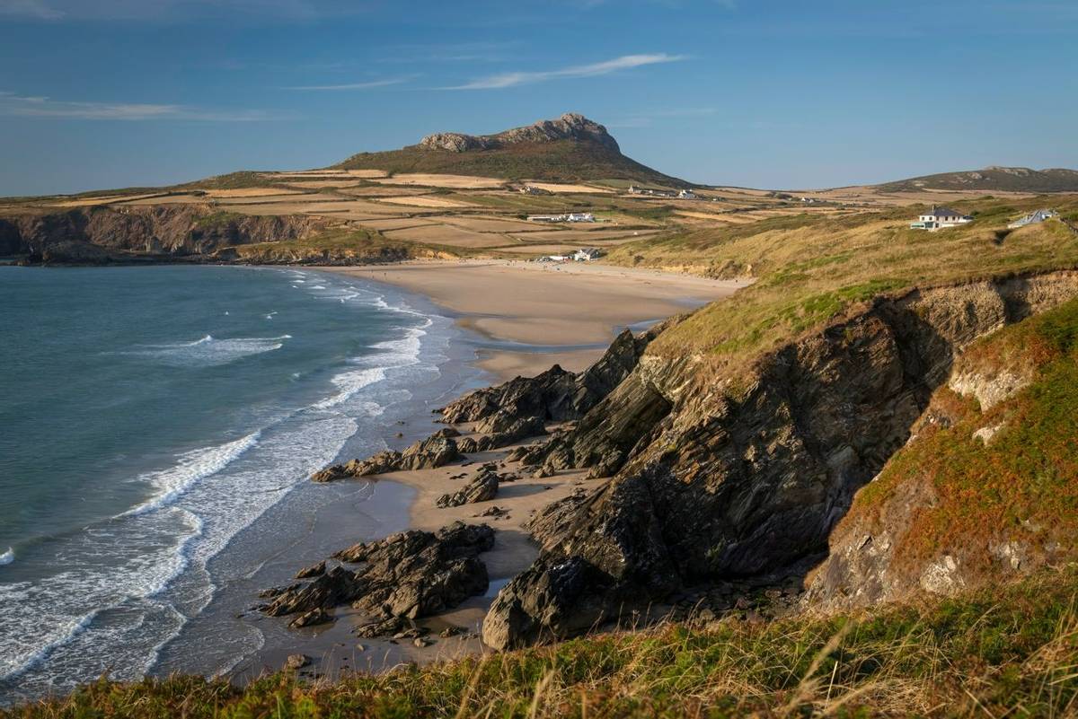 Whitesands Bay and Carn Llidi hill near St David's City in West Wales, a surfing destination with a shop and cafe.