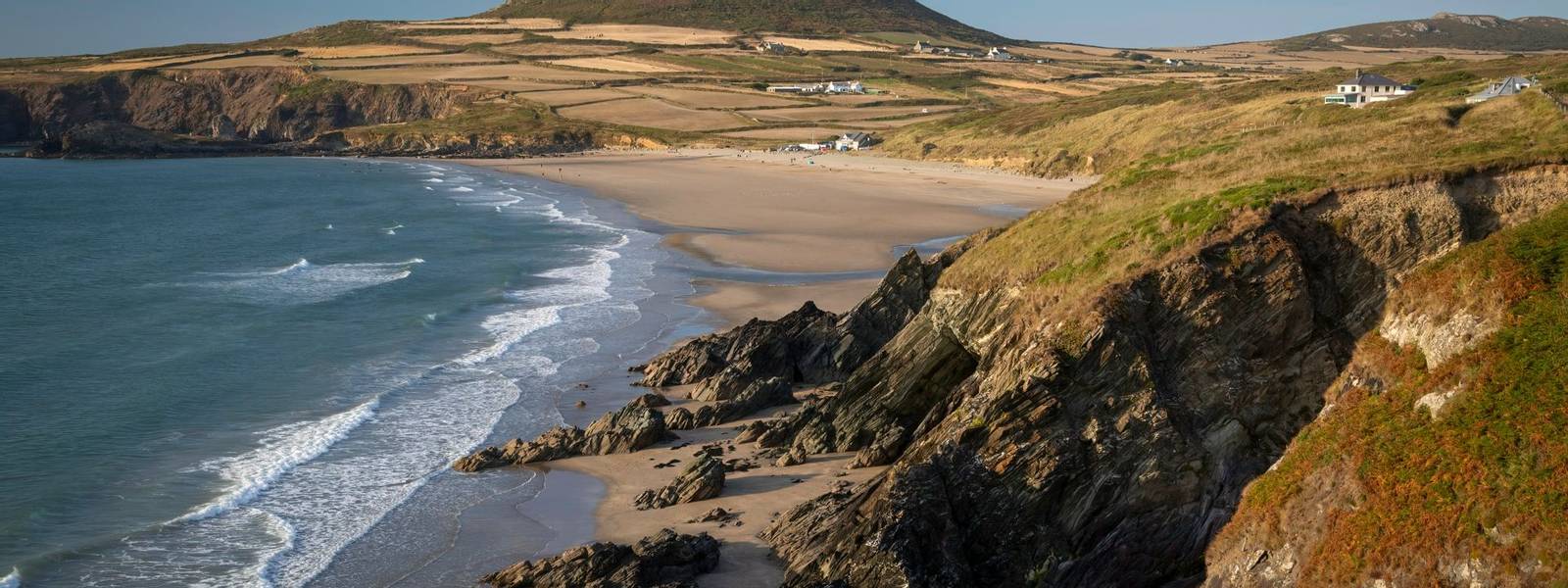 Whitesands Bay and Carn Llidi hill near St David's City in West Wales, a surfing destination with a shop and cafe.