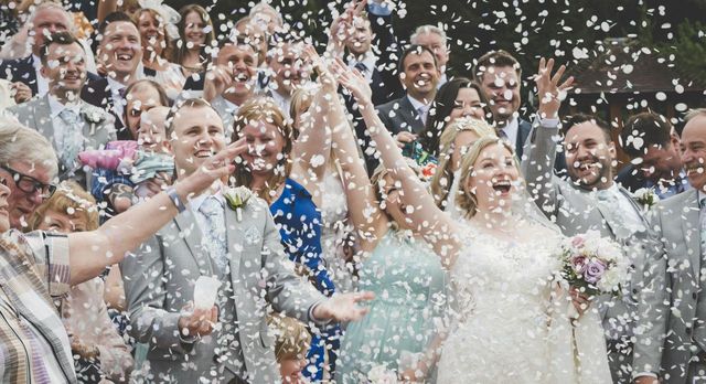 Wedding party throwing confetti outdoors