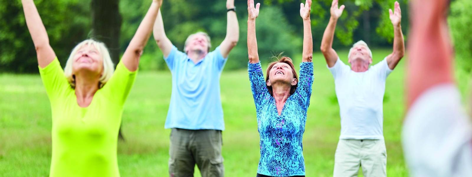 Aktive Senioren beim gesunden Stretching in einem Reha Fitness Kurs im Sommer