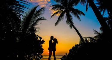 Silhouetted couple on a beach in the Maldives at Sunset