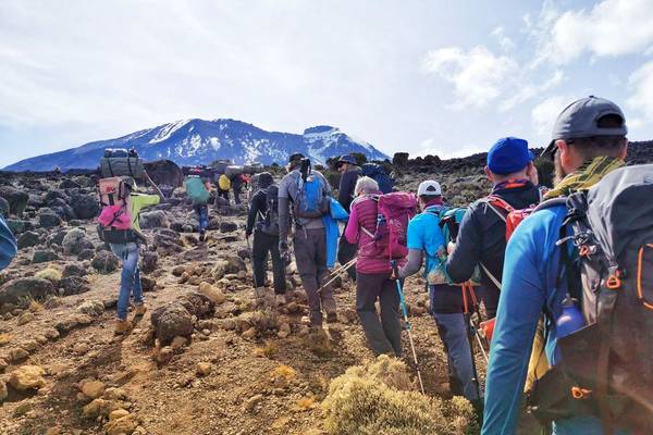 Hikers at the summit of Kilimanjaro, Uhuru Peak, holding up an EverTrek banner