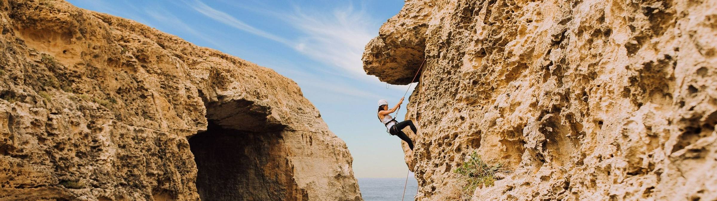 Young Woman Climbing Cliffs Of Gozo
