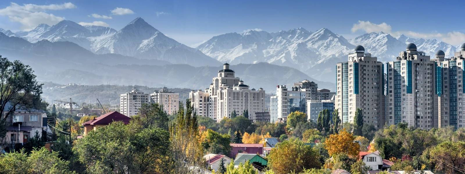 City landscape on a background of snow-capped mountains