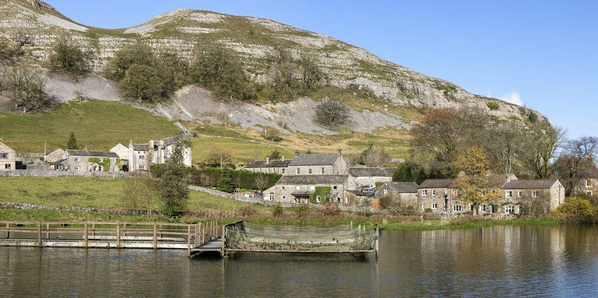 kilnsey crag village and fishing lake in wharfedale north yorkshire on sunny day