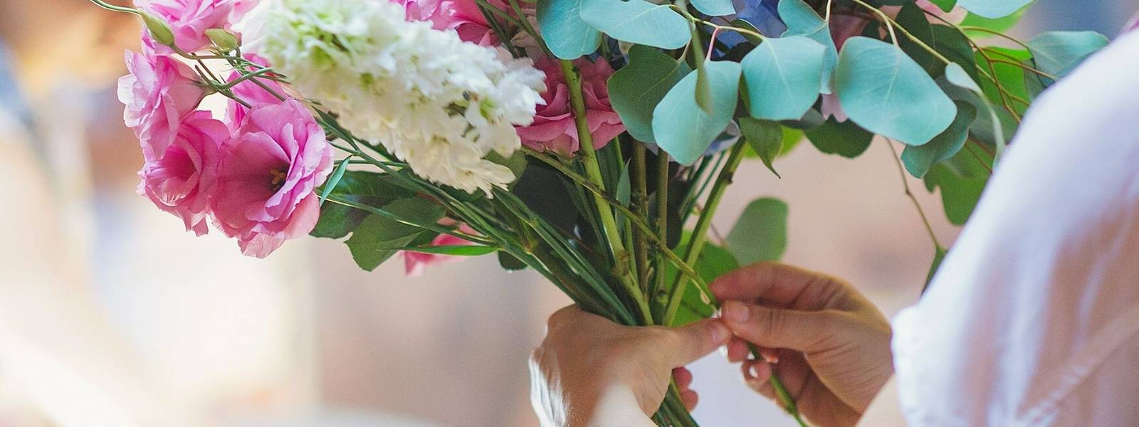 Hands of florist woman creating bouquets for wedding decoration