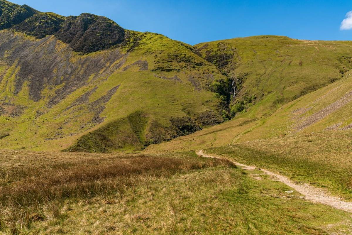 A footpath in the Howgill Fells with Cautley Spout in the background, near Low Haygarth, Cumbria, England, UK