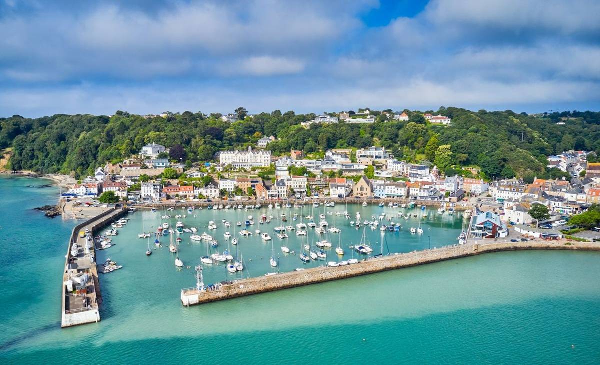 Airial drone image of St Aubn's Harbour and Village at high tide in the sunshine. Jersey Channel Islands