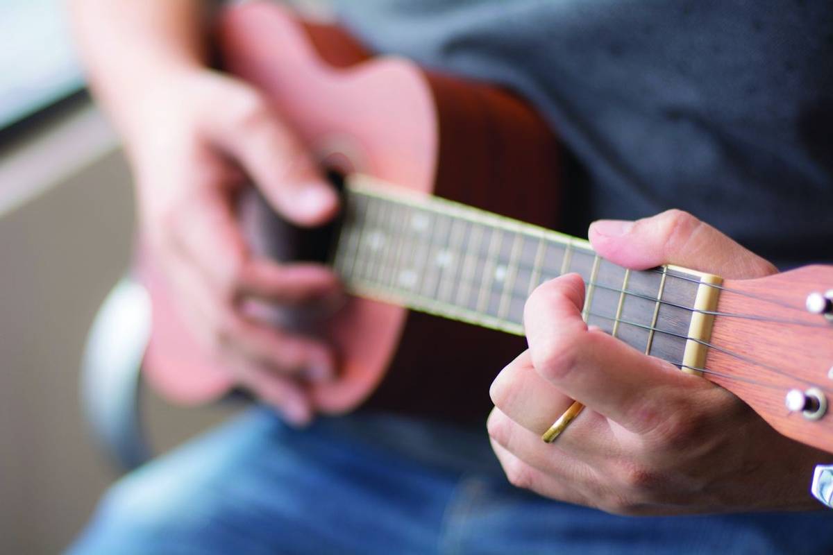 Man playing Ukelele with selective focus