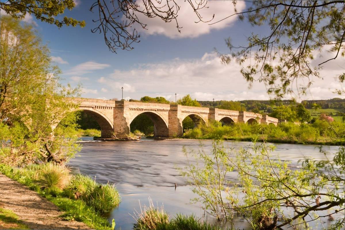 Bridge over the river Tyne leading into Corbidge village on a sunny spring day