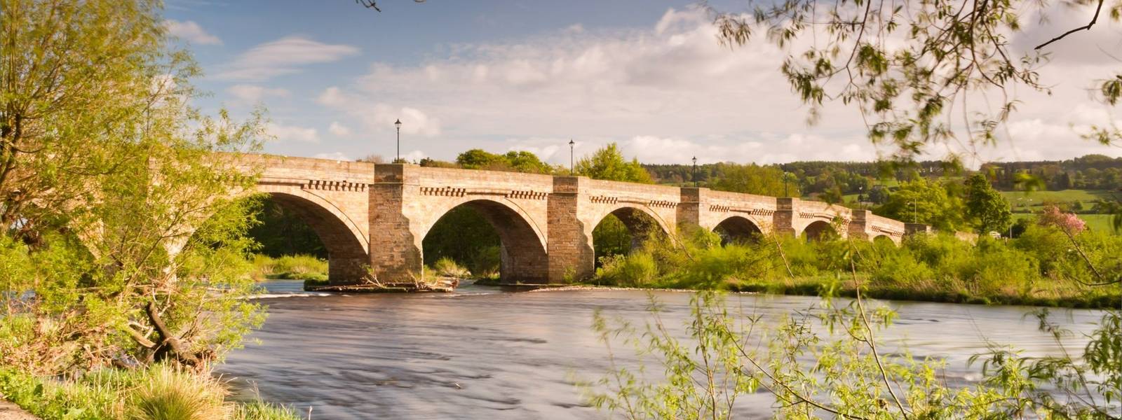 Bridge over the river Tyne leading into Corbidge village on a sunny spring day