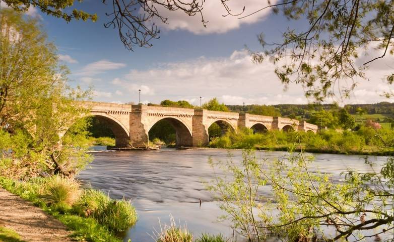 Bridge over the river Tyne leading into Corbidge village on a sunny spring day