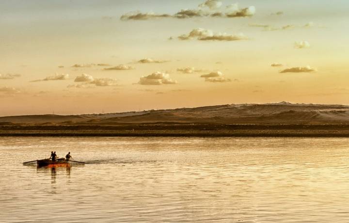 Traditional fishing boat at sunset in Suez canal, Egypt Traditional fishing boat at sunset in Suez canal, Egypt