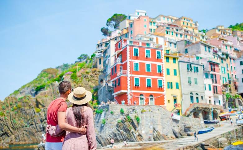 Young family with great view at old village Riomaggiore, Cinque Terre, Liguria, Italy. European italian vacation.