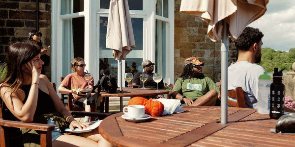 Group photo of 30+ HF Holidays guests, posing for the photo with a large green banner that reads 'HF Holidays: Walk Your Way'