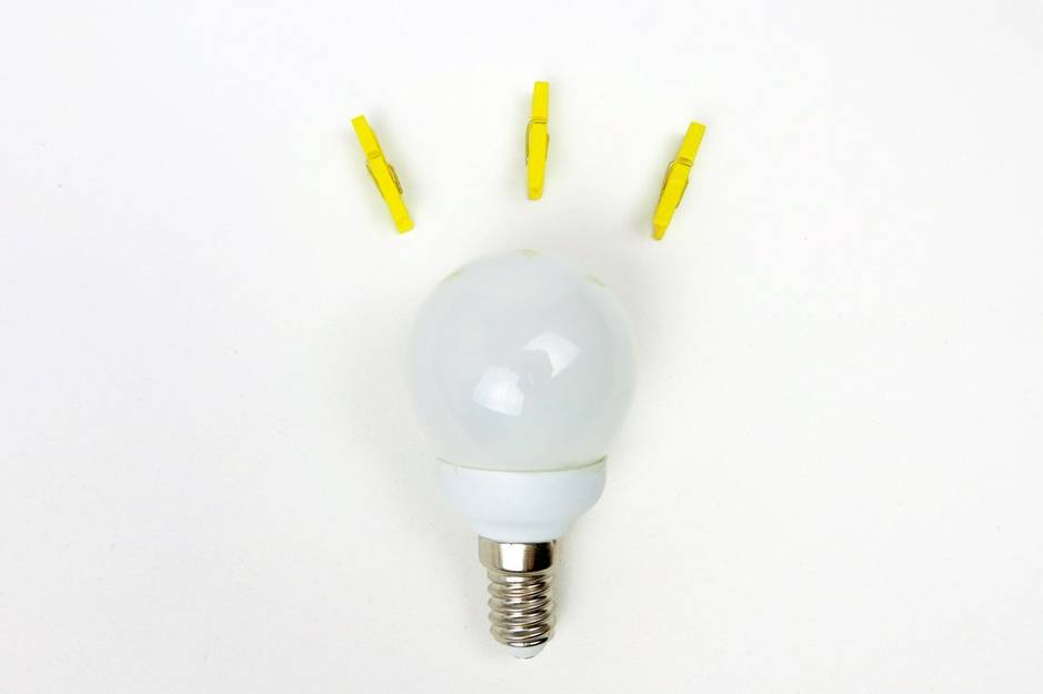 lightbulb with yellow pegs placed closeby to give the illusion of power or an idea being formed.
