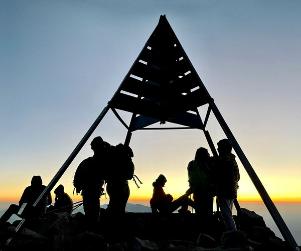 The summit marker of Mount Toubkal at sunrise on a clear day