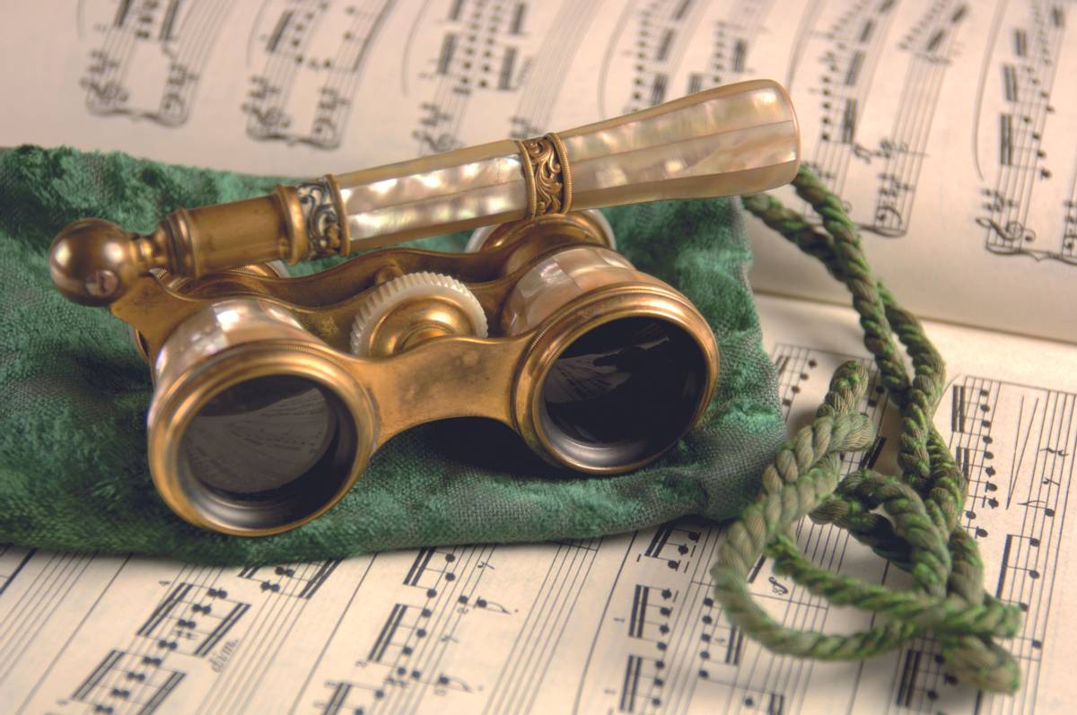 Antique opera glasses rest on a tattered velvet pouch and sheet music. Shallow DOF, Focus=camera right lens. 12MP camera.