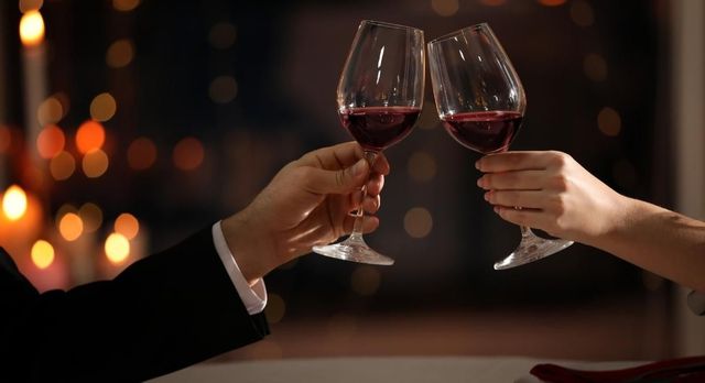 Couple on a date on a easter hotel break cheersing a glass of wine