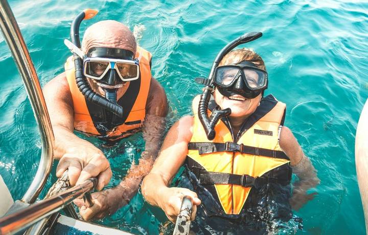 Retired couple taking happy selfie in tropical sea excursion with life vests and snorkel masks - Boat trip snorkeling in exo… Retired couple taking happy selfie in tropical sea excursion with life vests and snorkel masks - Boat trip snorkeling in exo…