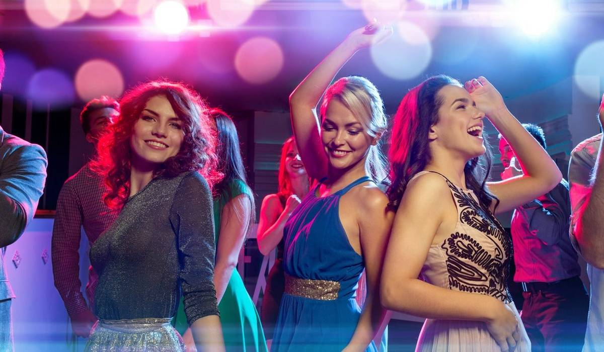 party, holidays, celebration, nightlife and people concept - smiling friends dancing in club
