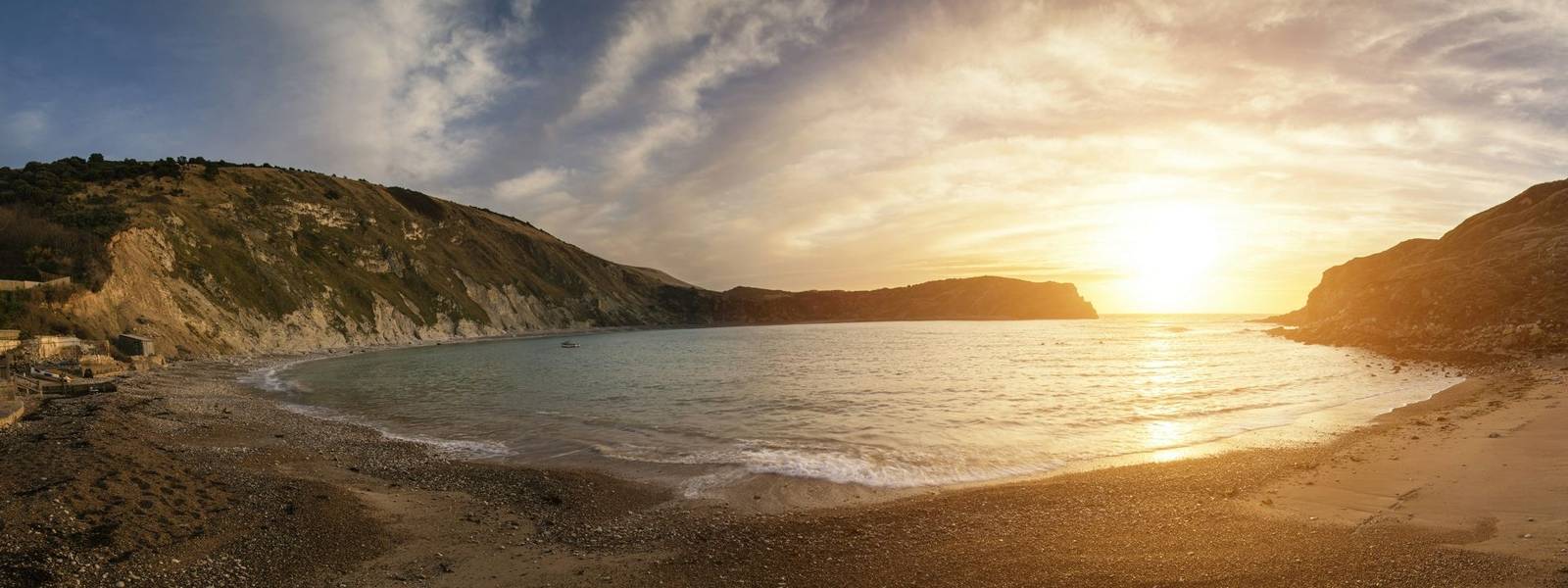 Beautiful sunrise panorama landscape over Lulworth Cove in Dorset