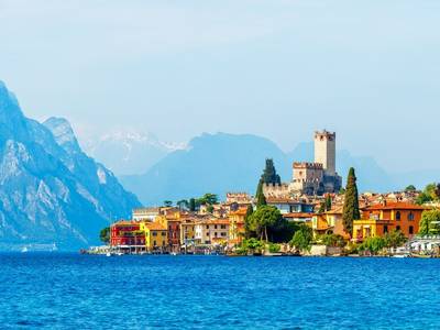Ancient tower and fortress in old town malcesine at garda lake veneto region italy high snowbound top mountains on backgroun…