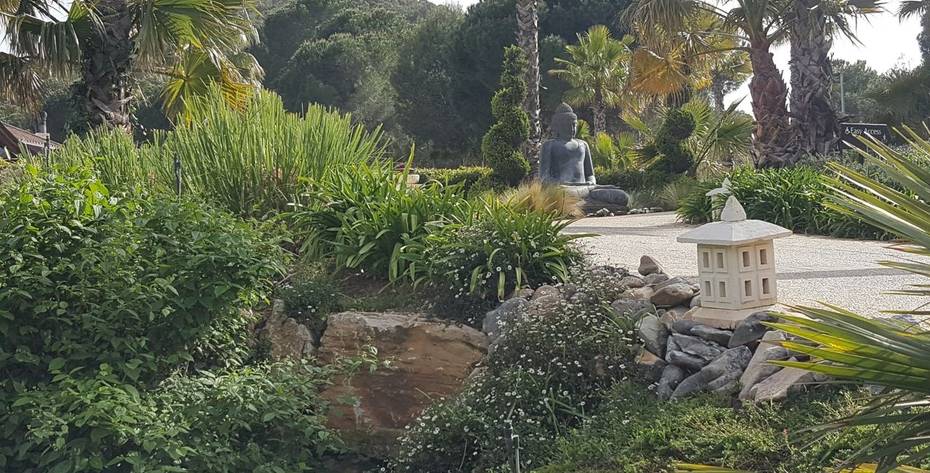 A pathway leading to small Buddha statue outside Shanti Som 