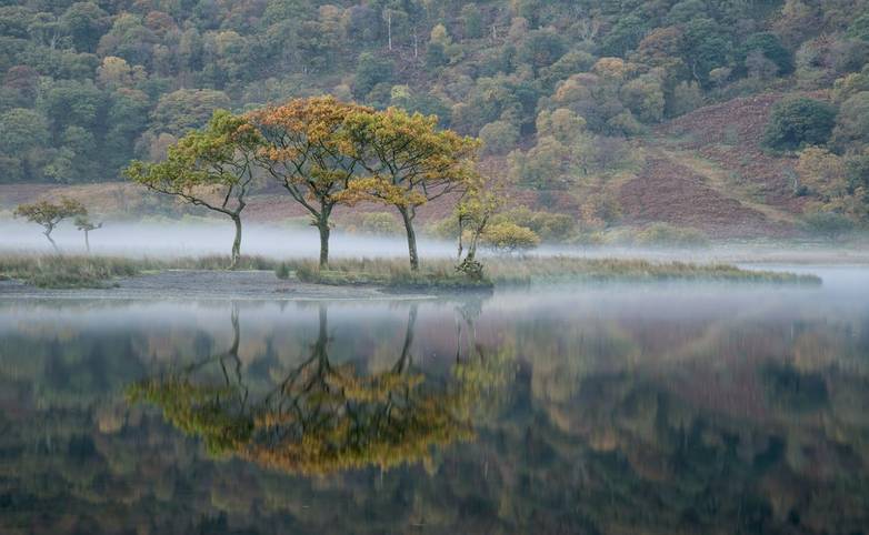 Stunning Winter foggy sunrise on Crummock Water in Lake District England