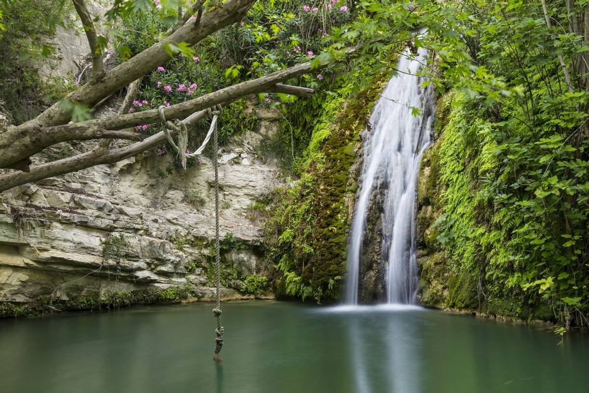 Waterfall falling into a  lake. Bath of Aphrodite. Cyprus. Tourist destination, tourist attraction, famous mythological site