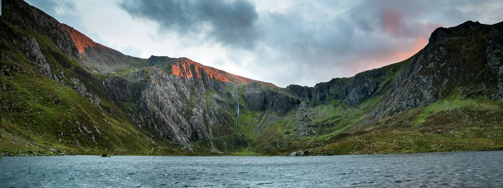 Beautiful sunset landscape image of Llyn Idwal and Devil's Kitchen in Snowdoina during Autumn evening