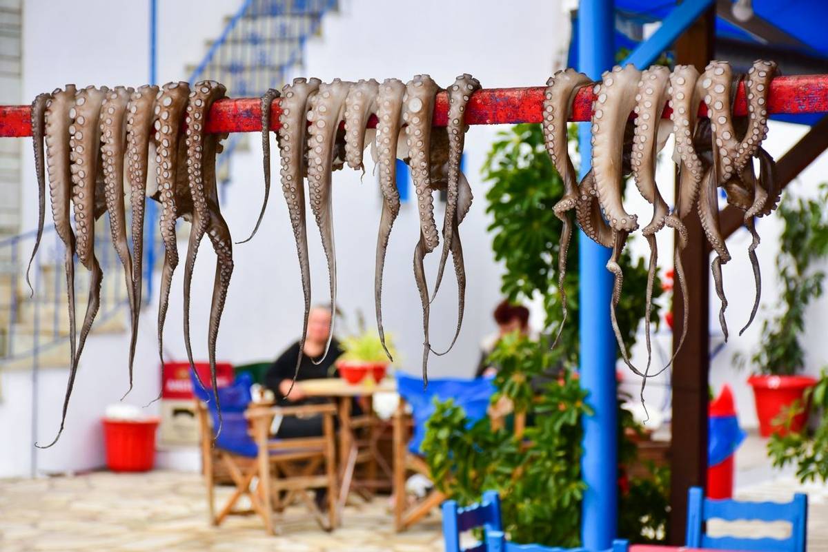 Greek taverna restaurant with calamari sea food displayed in the sun for roasting