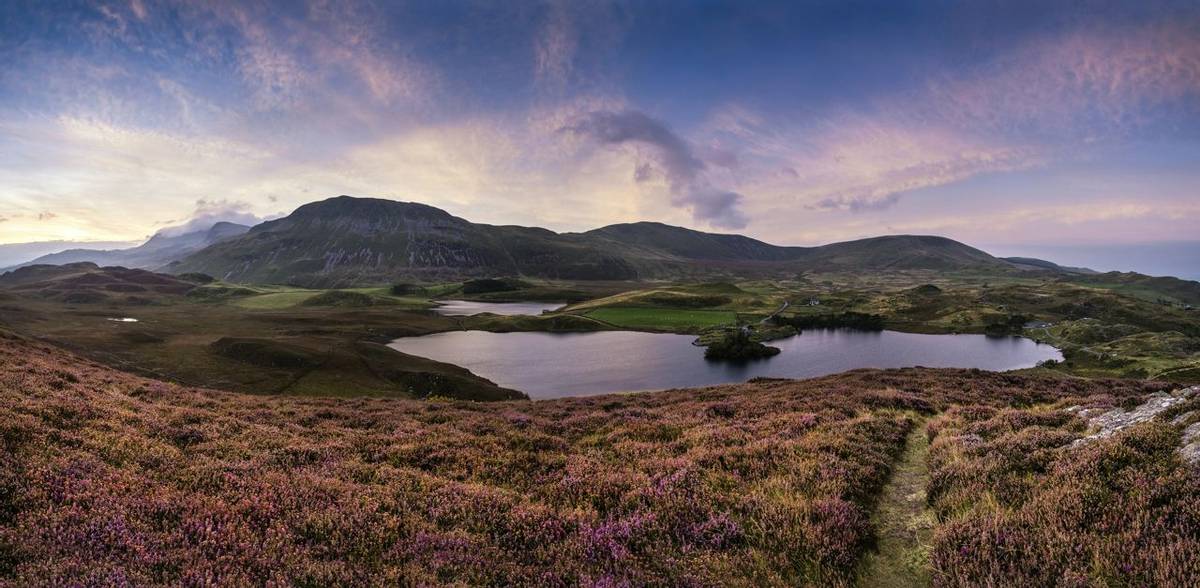 Beautiful vibrant sunrise landscape over Cregennen Lakes with Cadair Idris in background in Snowdonia