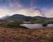 Beautiful vibrant sunrise landscape over Cregennen Lakes with Cadair Idris in background in Snowdonia