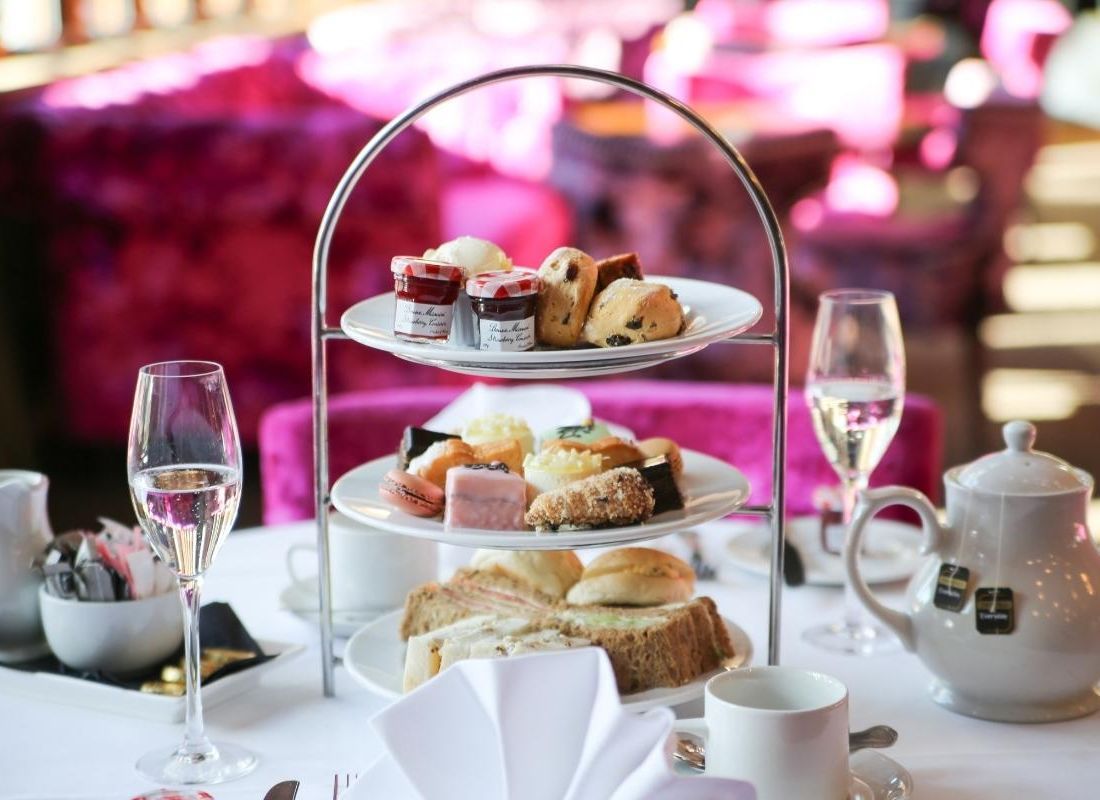 Three tiers of afternoon tea with a glass of Prosecco